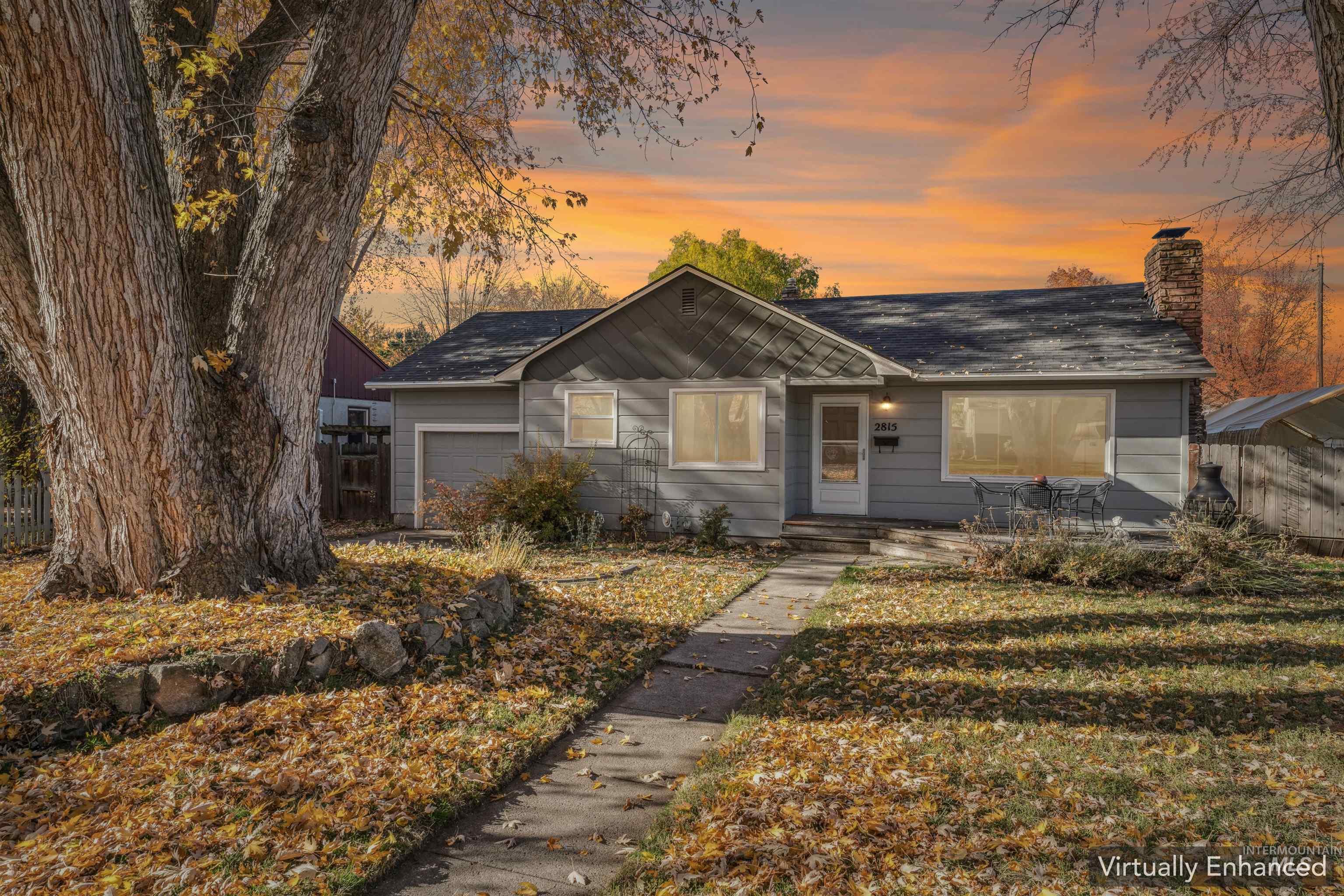 View of front of property with a chimney and a garage