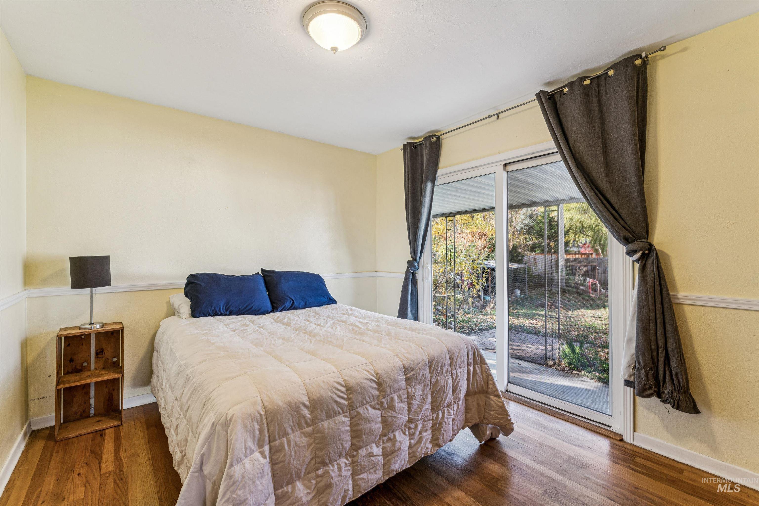 Bedroom featuring wood finished floors and access to exterior