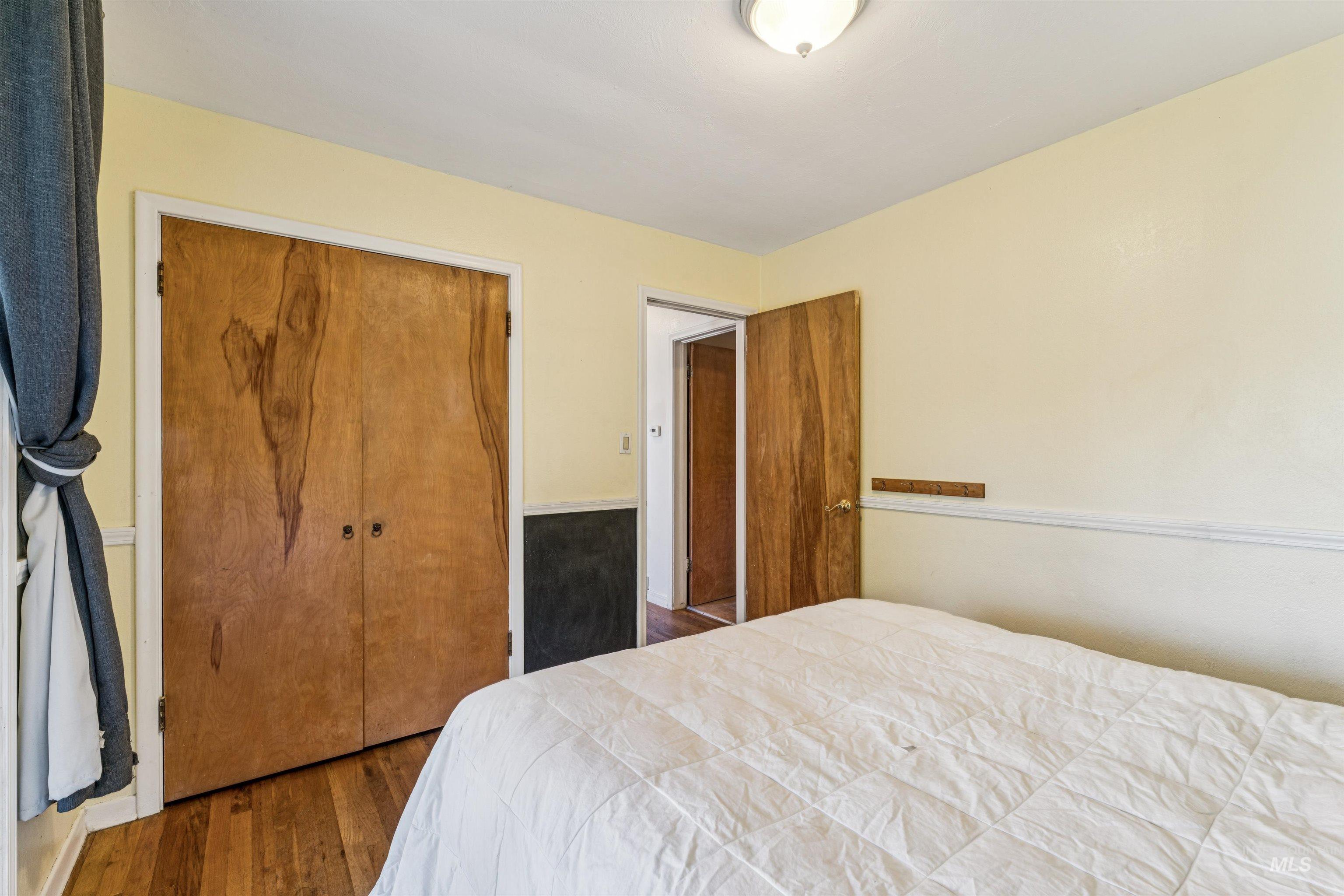 Bedroom featuring wood finished floors and a closet