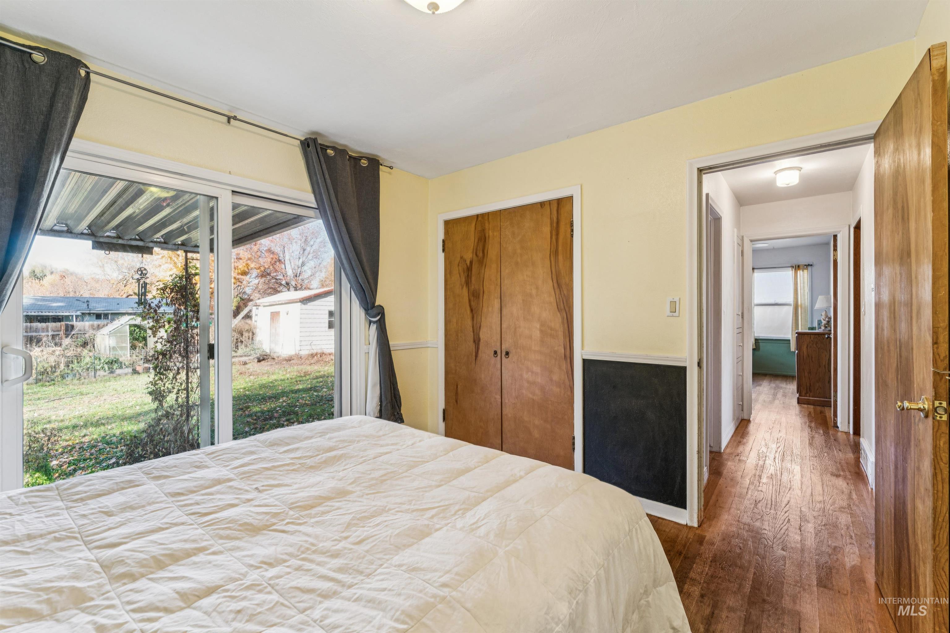 Bedroom featuring hardwood / wood-style floors, a closet, and access to outside