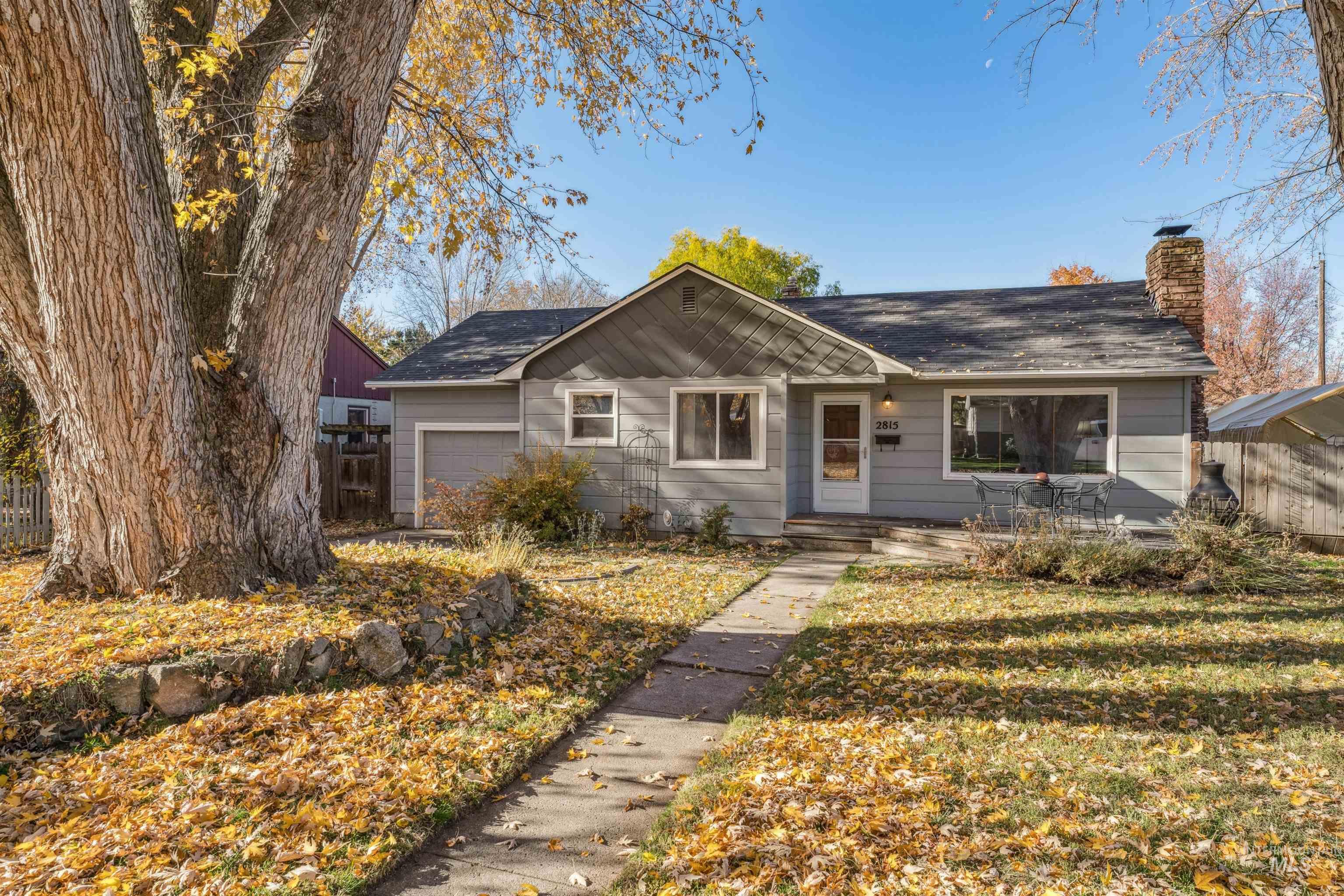 View of front of property featuring a chimney and an attached garage