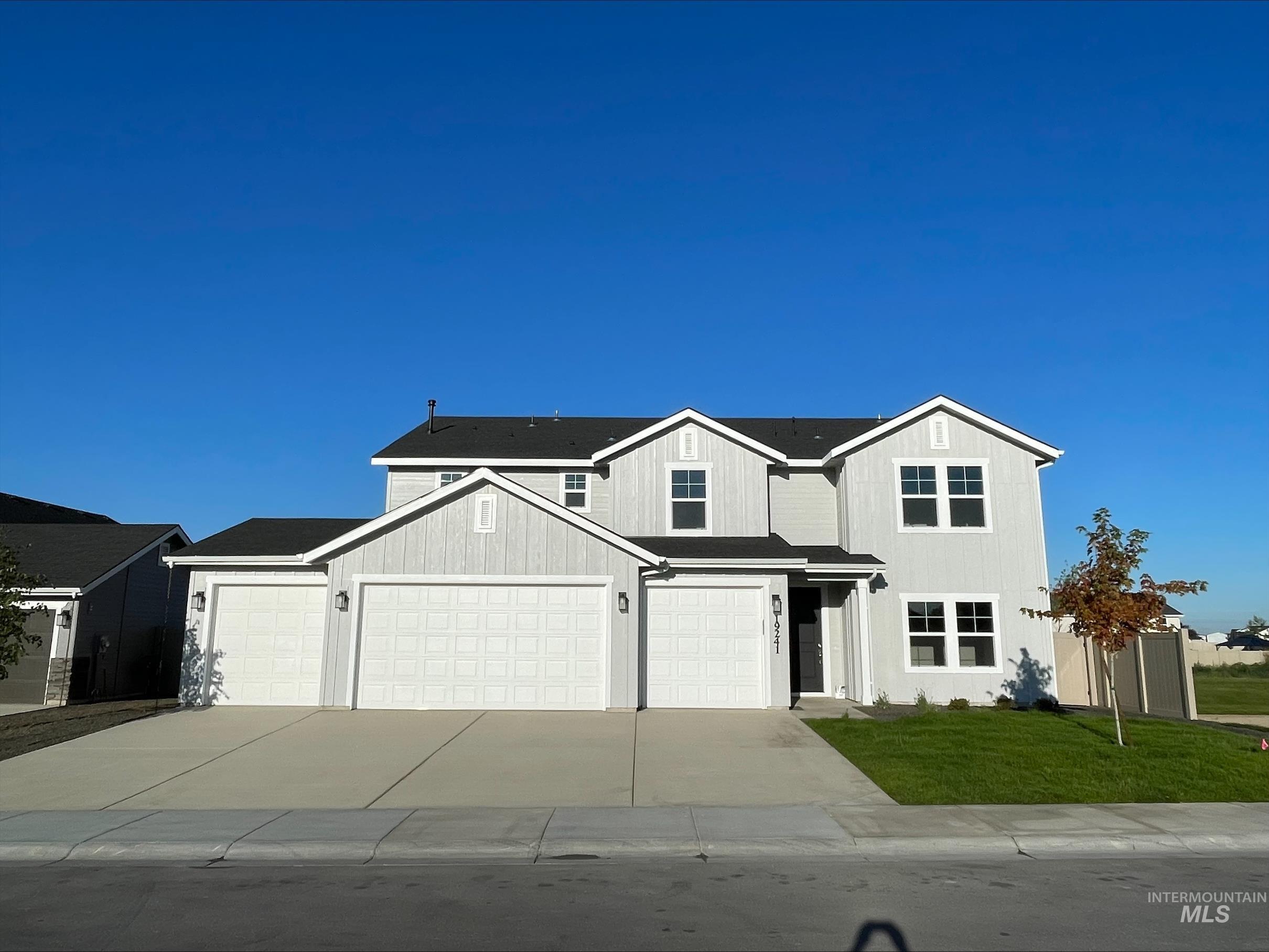 View of front facade featuring driveway, a front lawn, and an attached garage