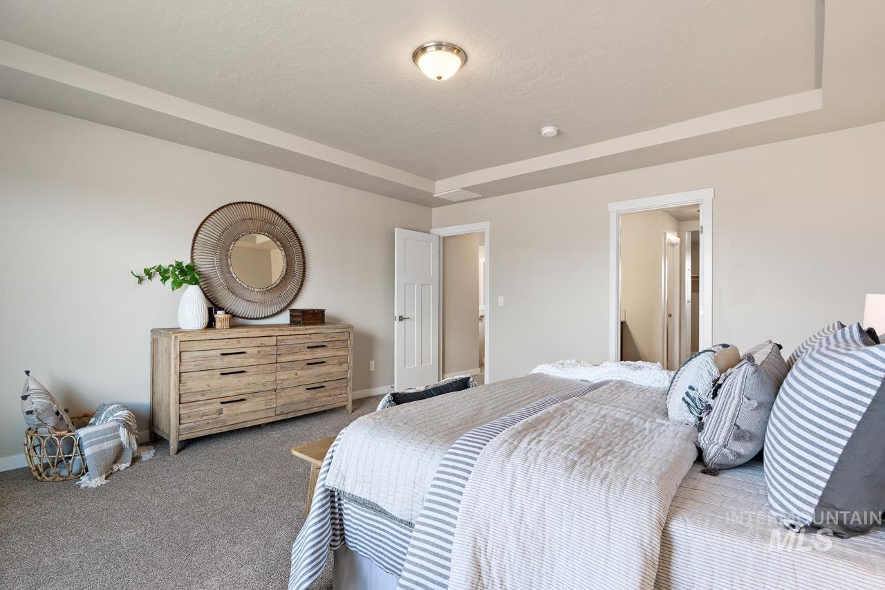 Bedroom featuring carpet floors and a raised ceiling