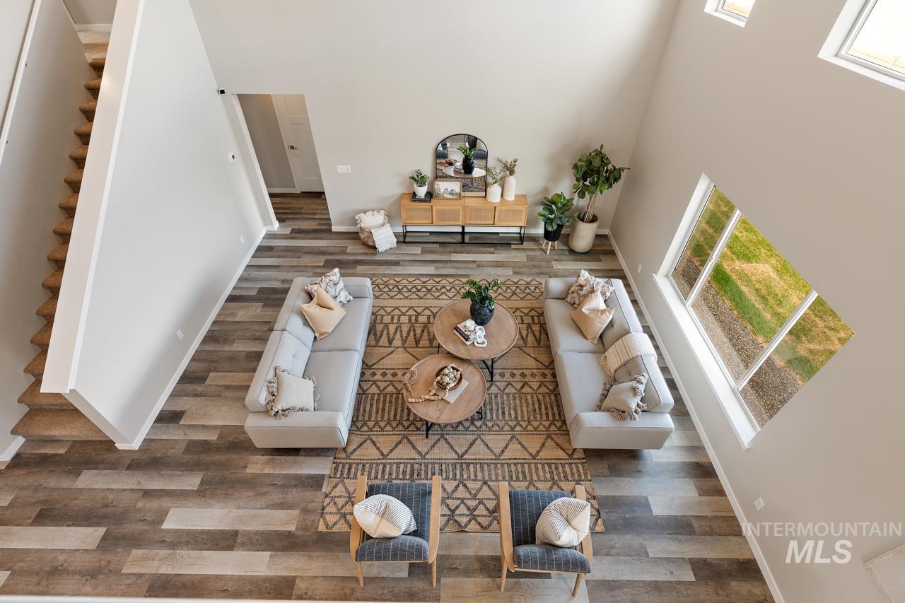 Living area featuring wood finished floors and a towering ceiling