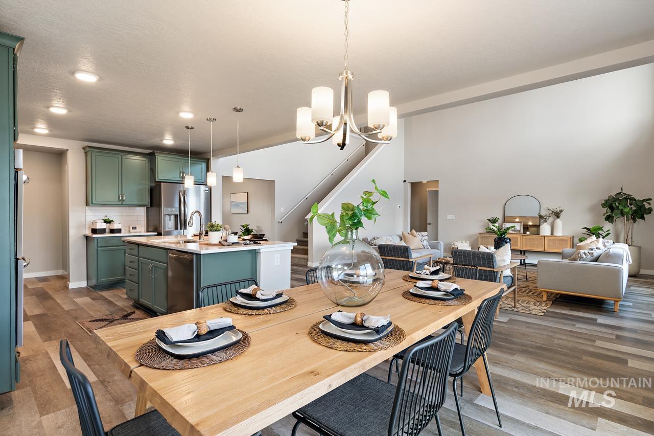 Dining space featuring stairway, wood finished floors, a chandelier, and recessed lighting