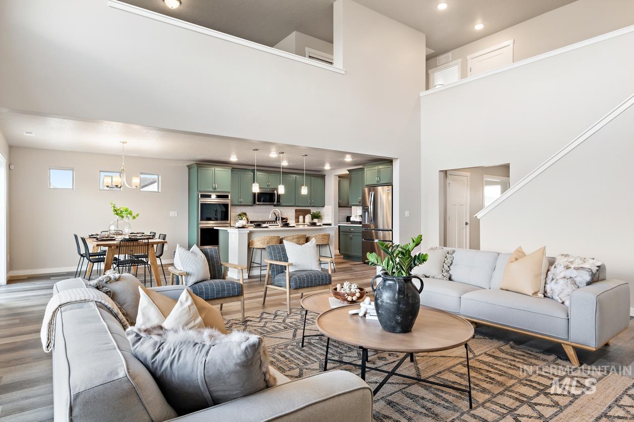 Living room featuring light wood-style flooring, recessed lighting, a high ceiling, and a chandelier