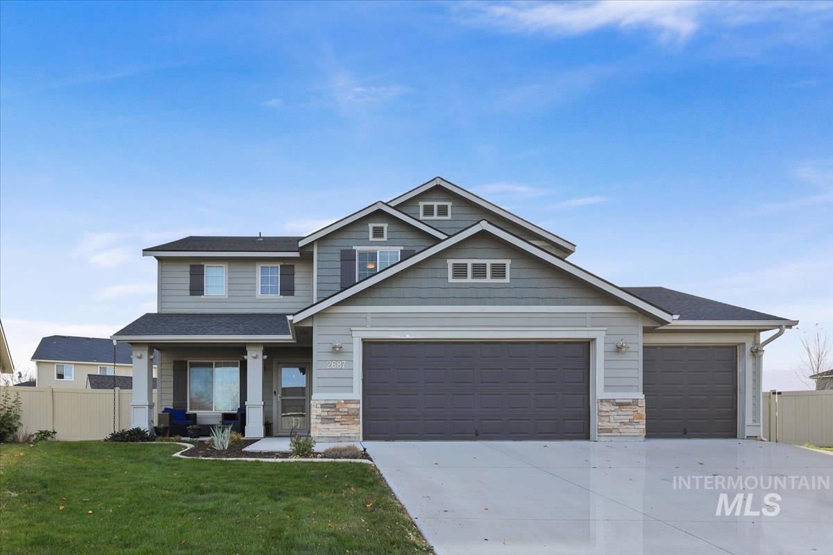 Craftsman-style home with concrete driveway, stone siding, a porch, and an attached garage