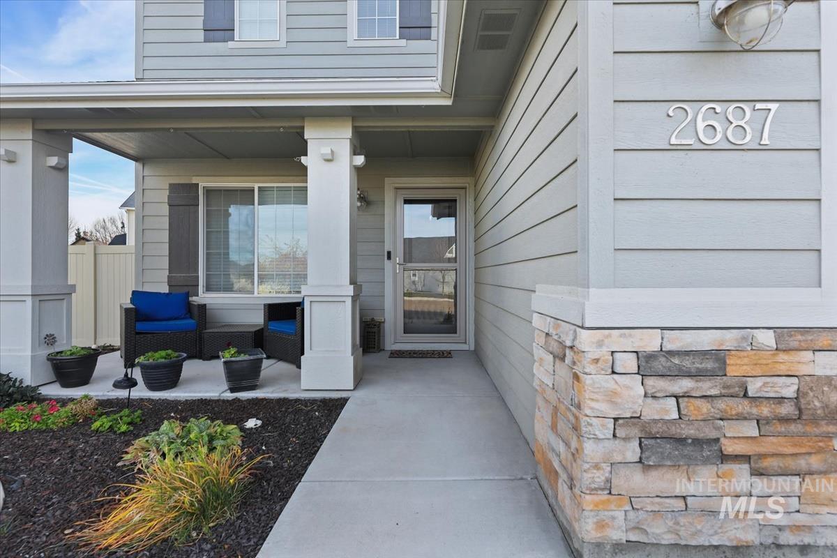 Property entrance featuring a porch and stone siding