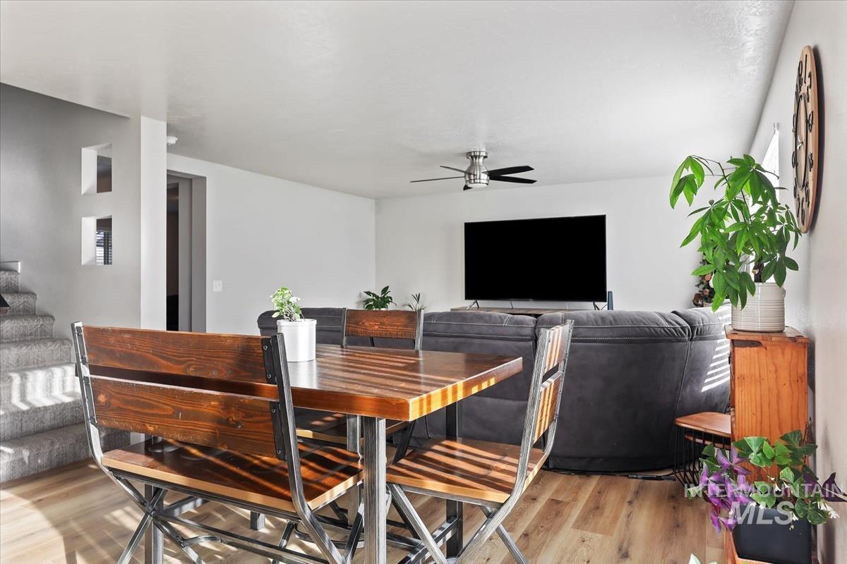 Dining area with light wood-style floors and a ceiling fan
