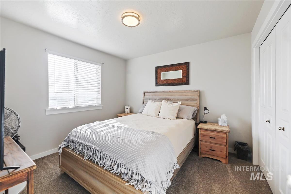 Bedroom featuring a closet and dark colored carpet