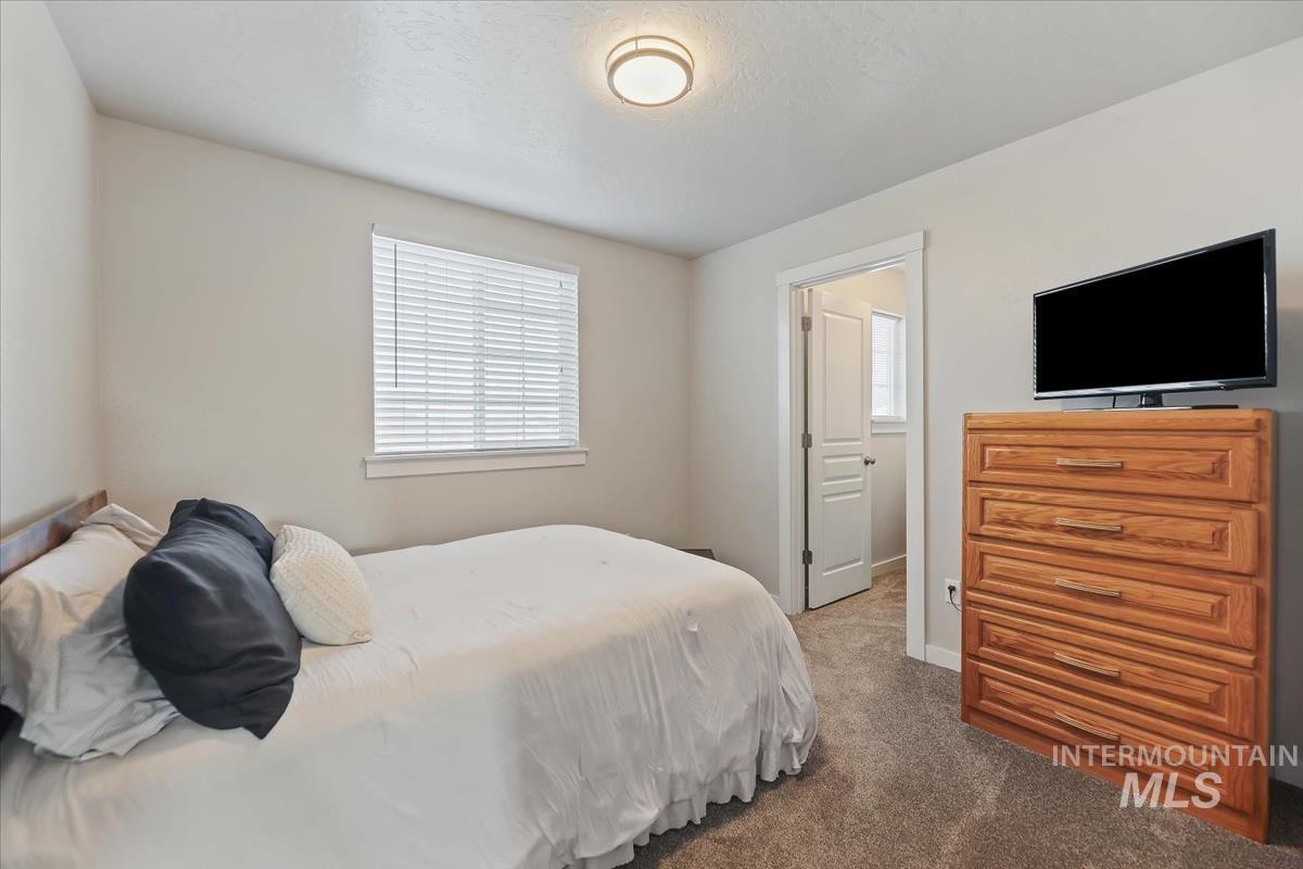 Bedroom featuring dark colored carpet and a textured ceiling