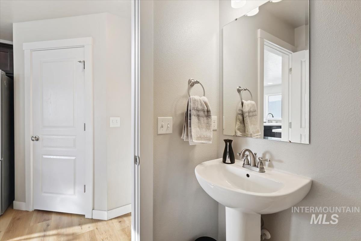 Bathroom with light wood-type flooring and a textured wall