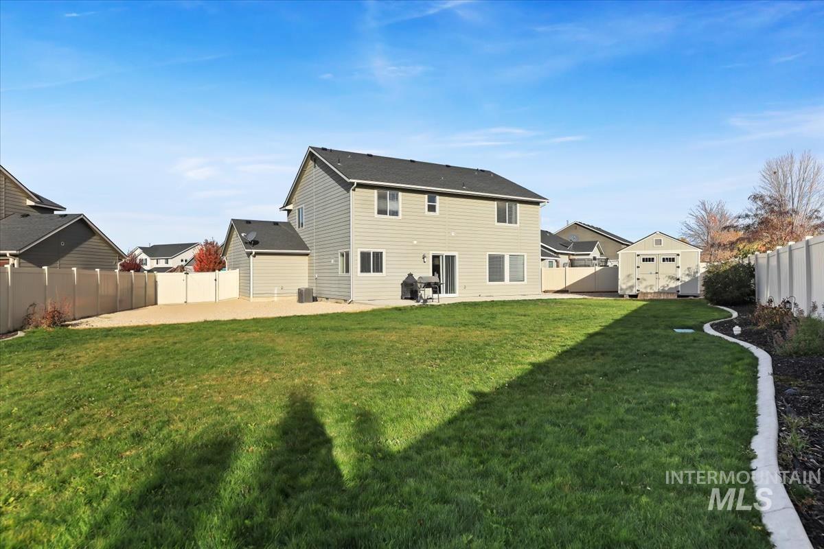 Back of house featuring a fenced backyard, a patio, and an outdoor structure
