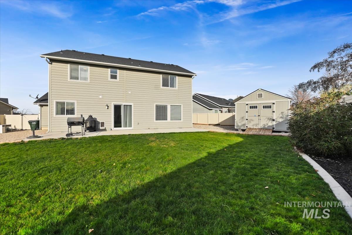 Rear view of property with a patio, a storage shed, and a fenced backyard