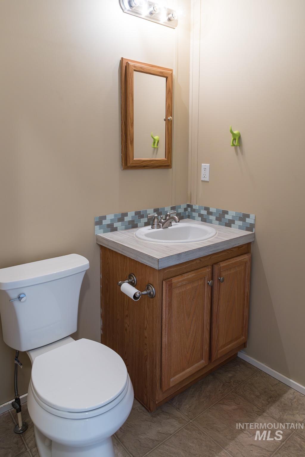 Bathroom with vanity, backsplash, and light tile patterned flooring