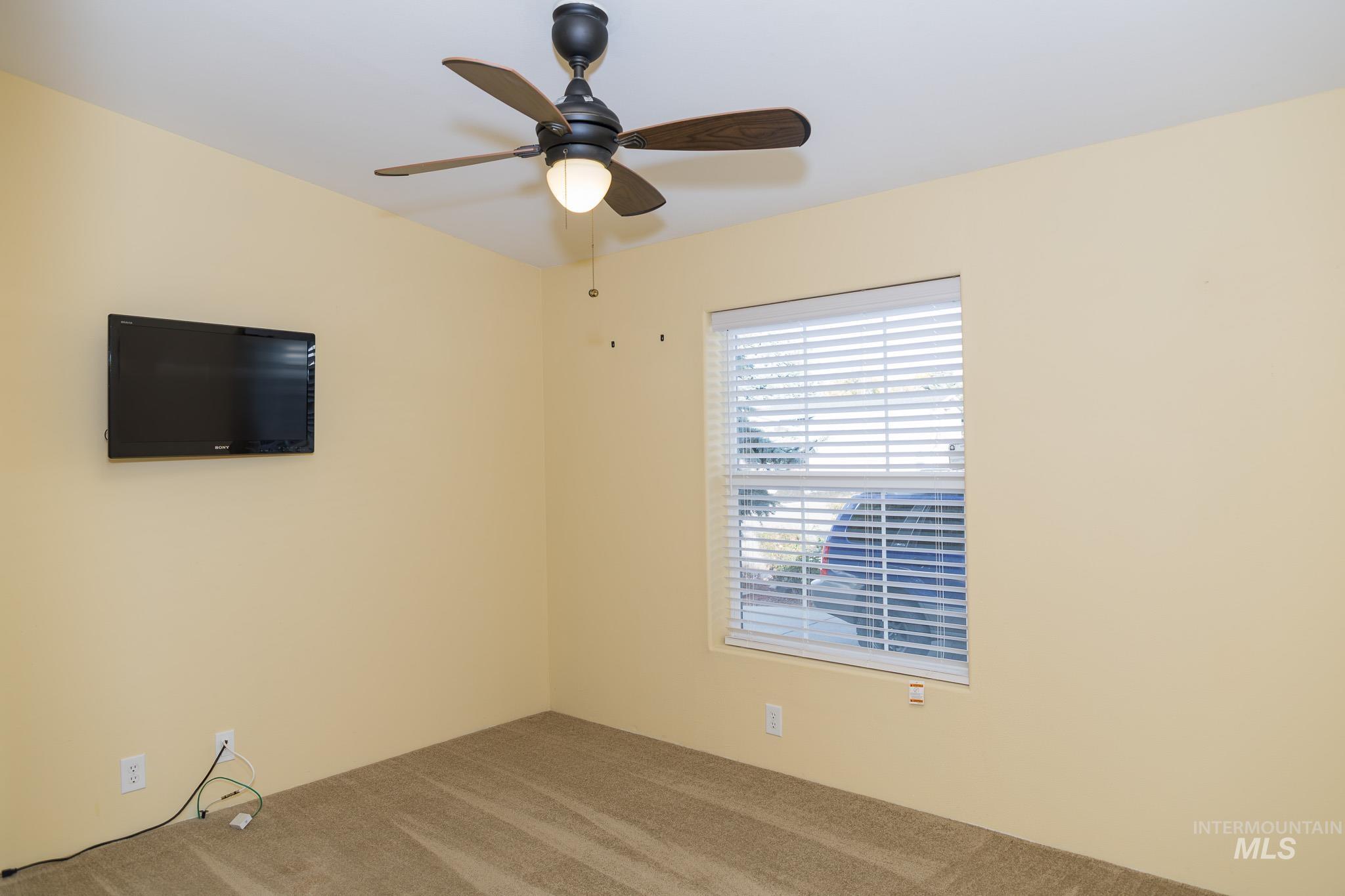 Empty room featuring carpet and ceiling fan