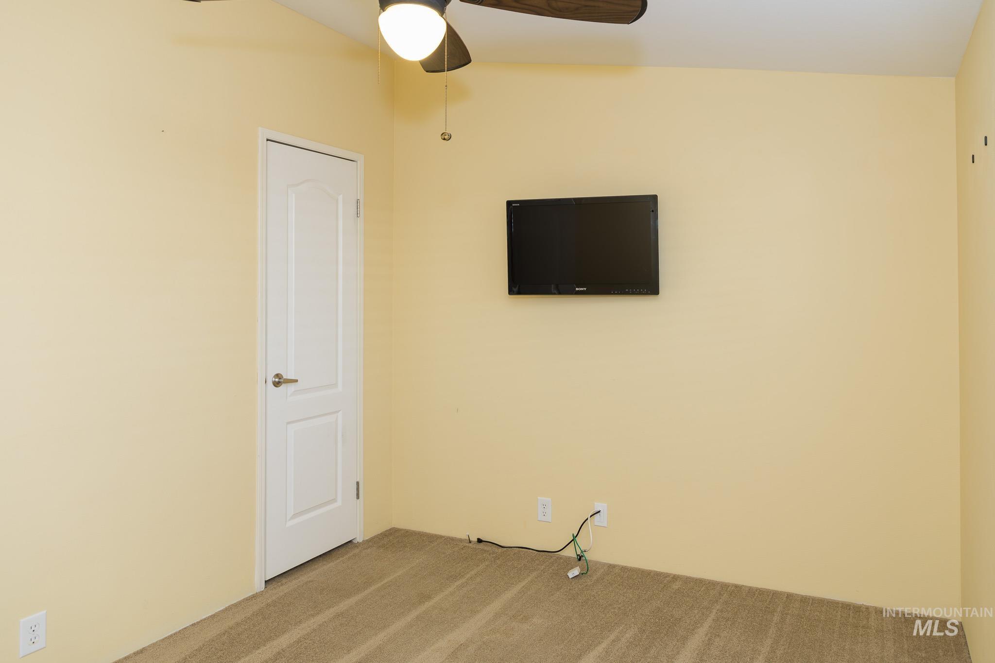 Spare room featuring carpet floors and a ceiling fan