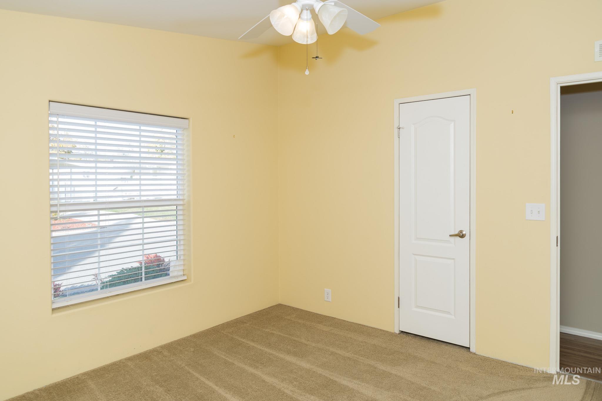 Unfurnished bedroom featuring carpet flooring and ceiling fan