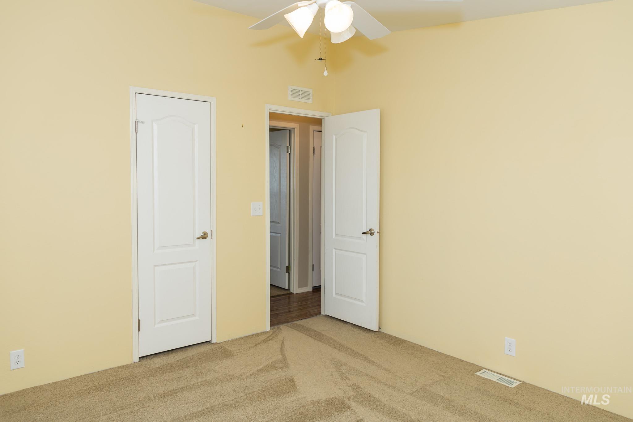 Unfurnished bedroom with carpet flooring and a ceiling fan