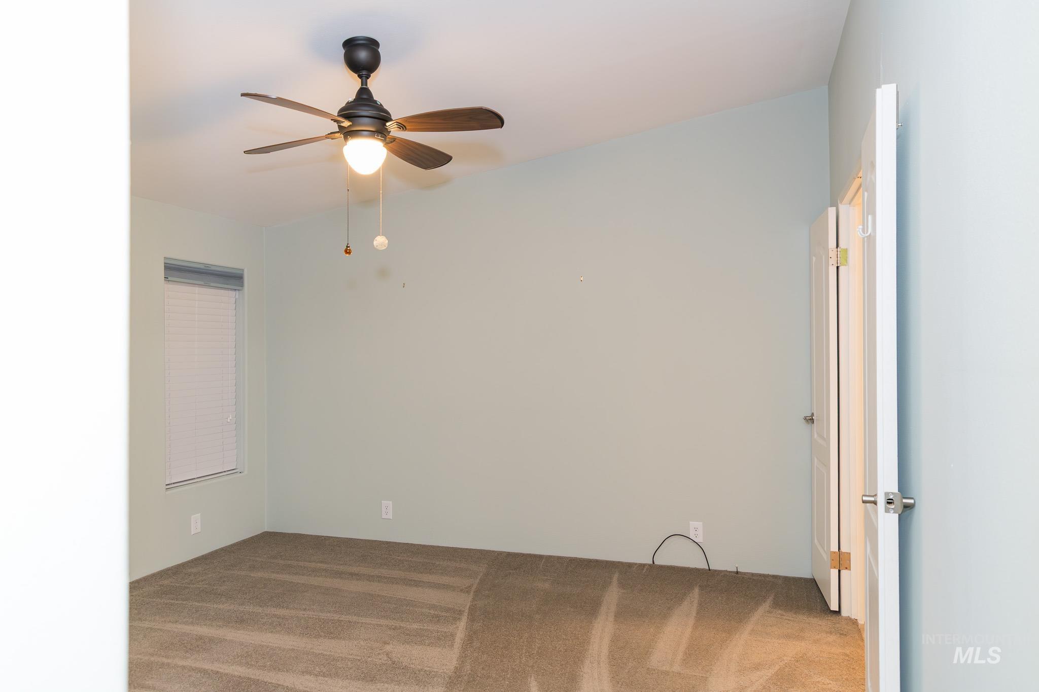 Spare room with carpet and a ceiling fan