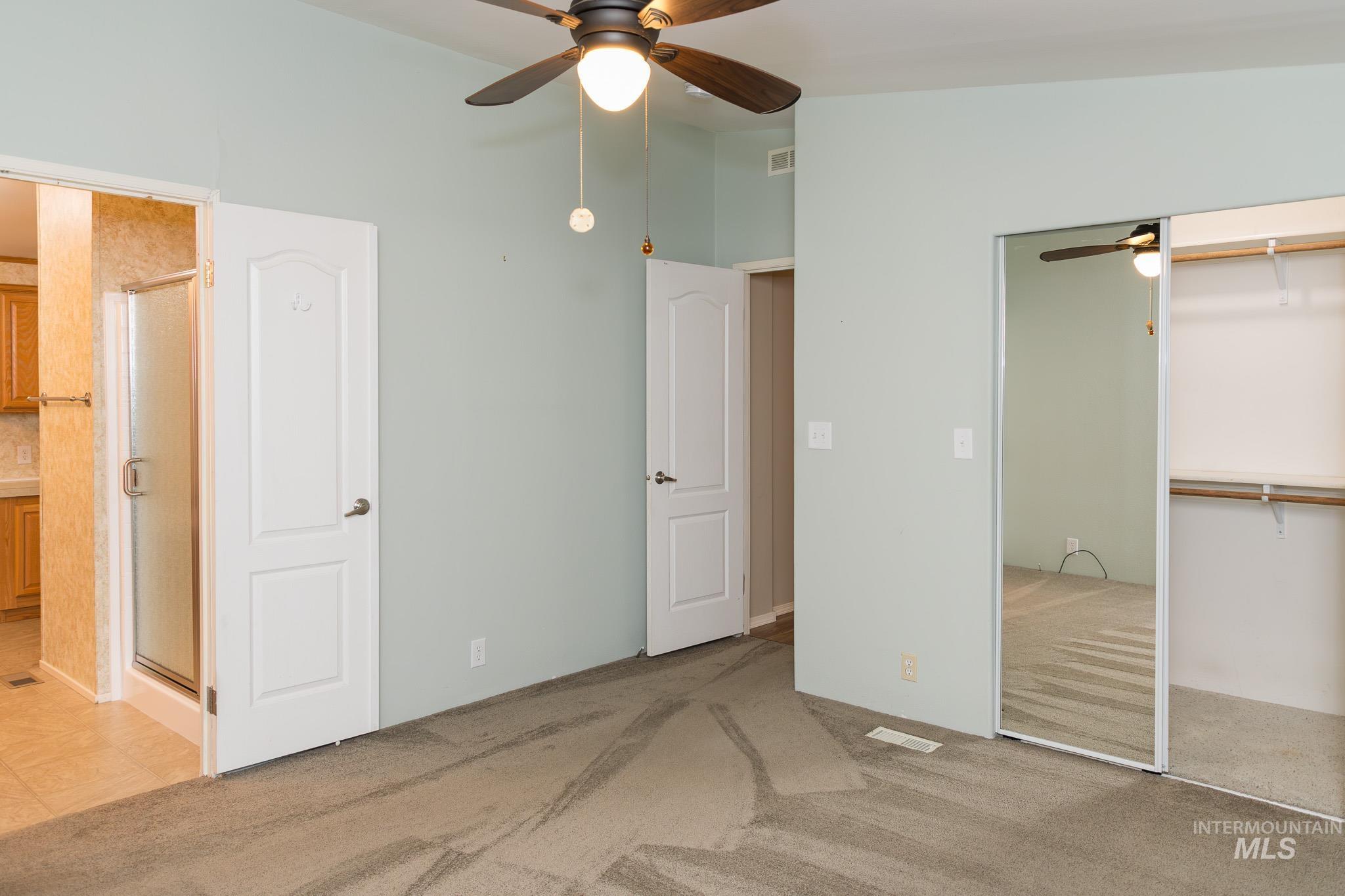 Unfurnished bedroom featuring ceiling fan, light colored carpet, and a closet