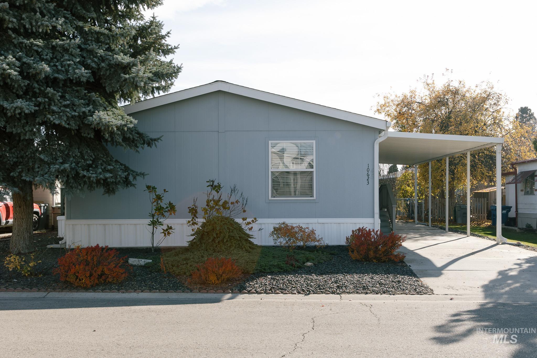 View of side of property featuring concrete driveway and a carport