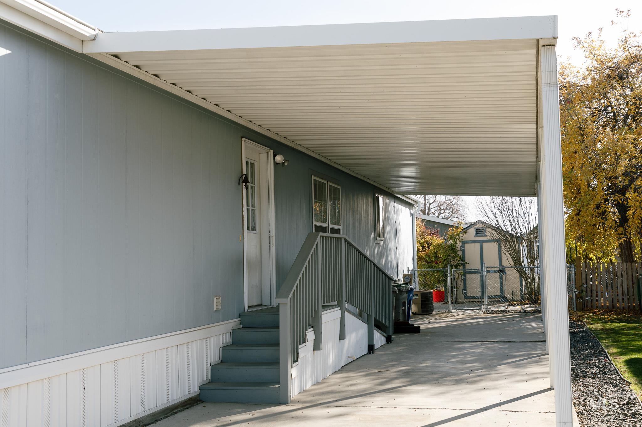 View of patio with an attached carport and a storage shed
