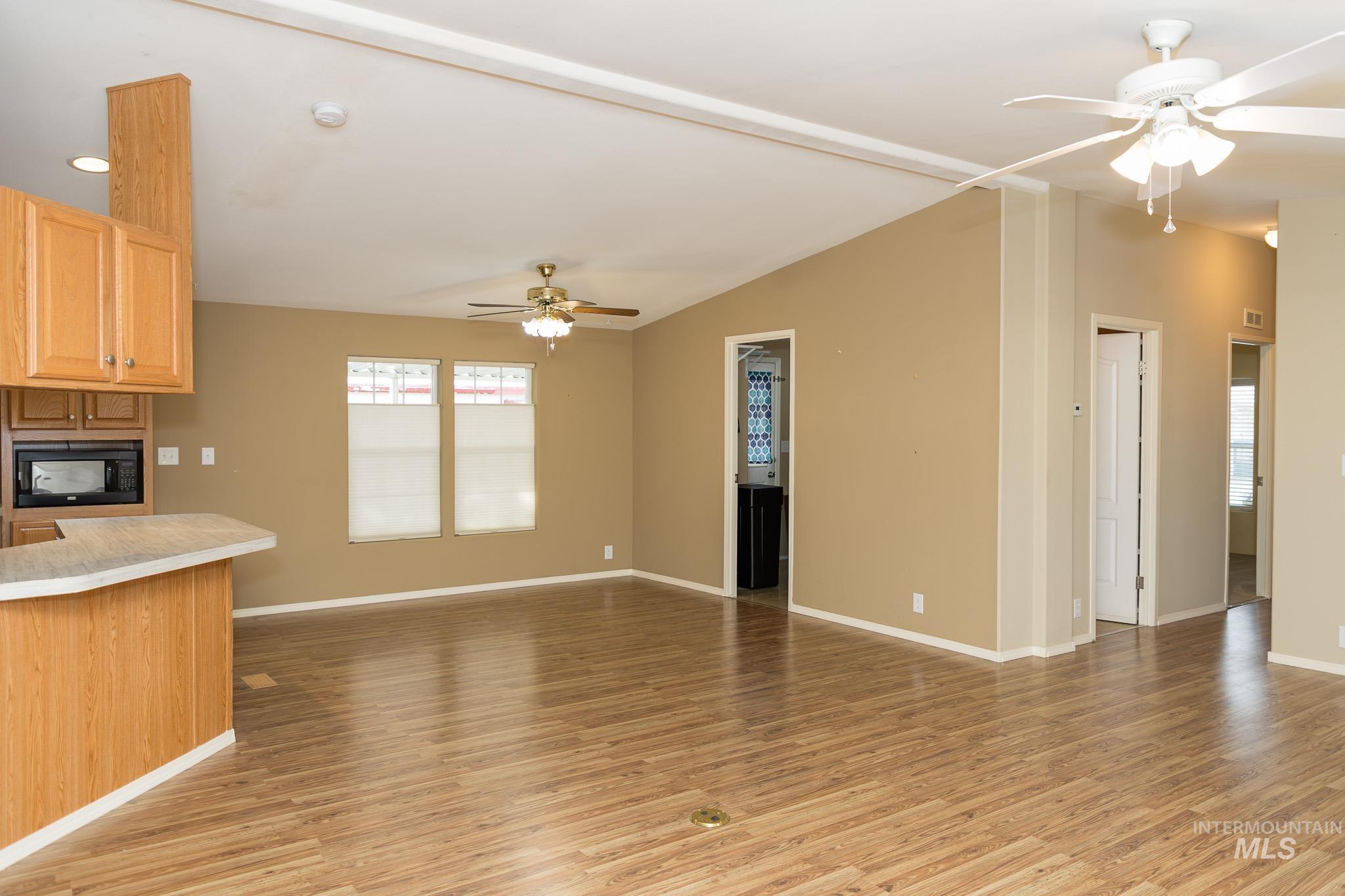 Unfurnished living room featuring ceiling fan and light wood-style flooring