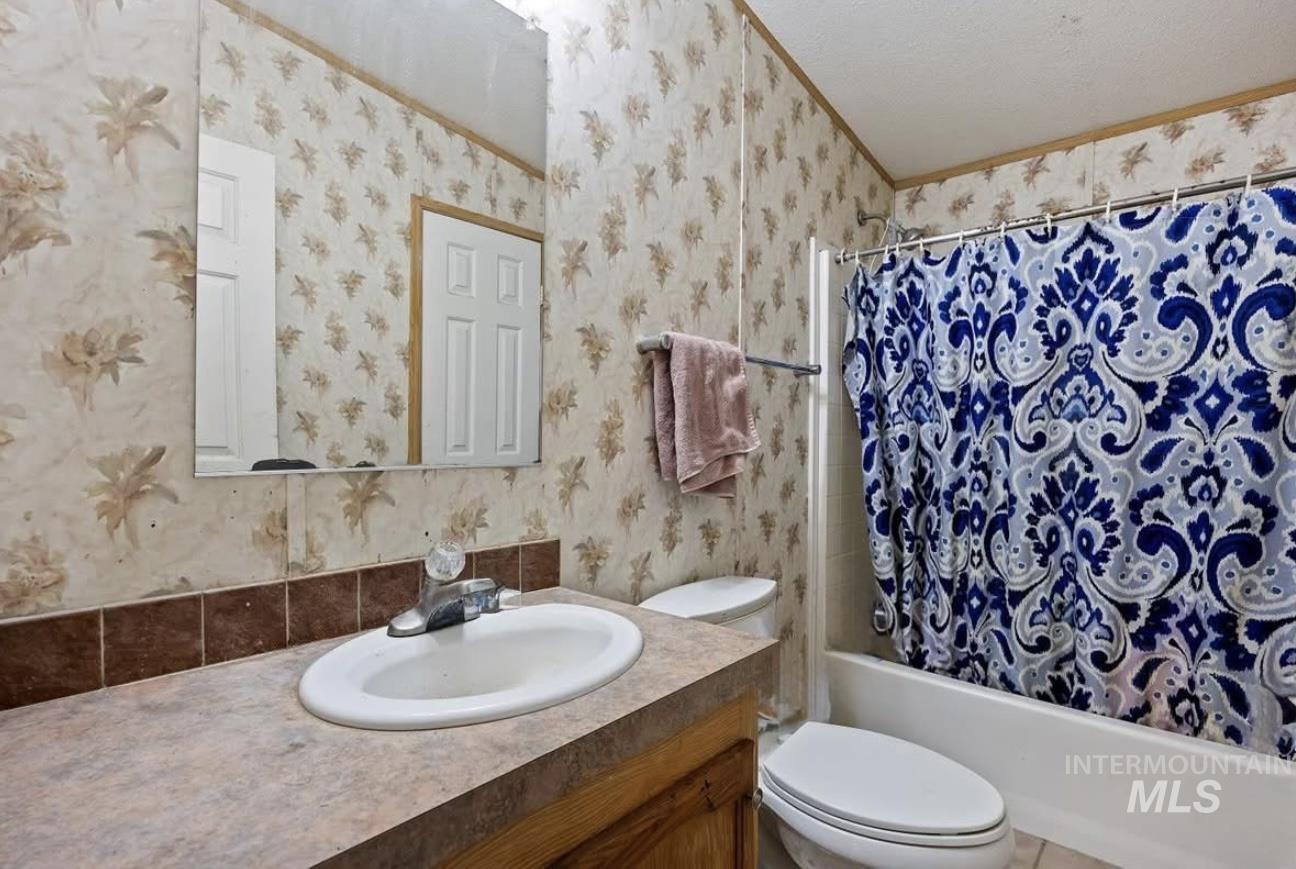 Full bathroom with shower / bath combo with shower curtain and vanity