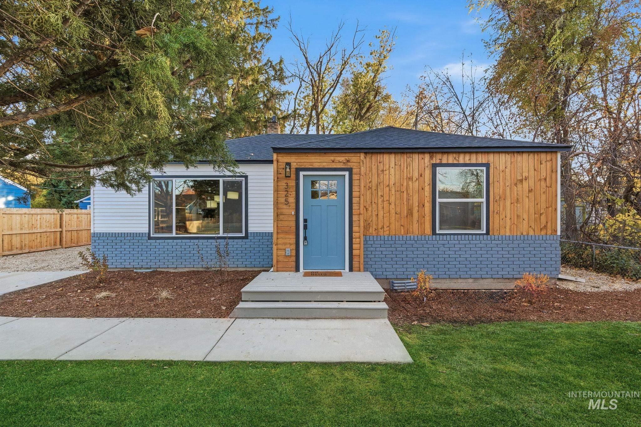 View of front of property featuring brick siding and roof with shingles
