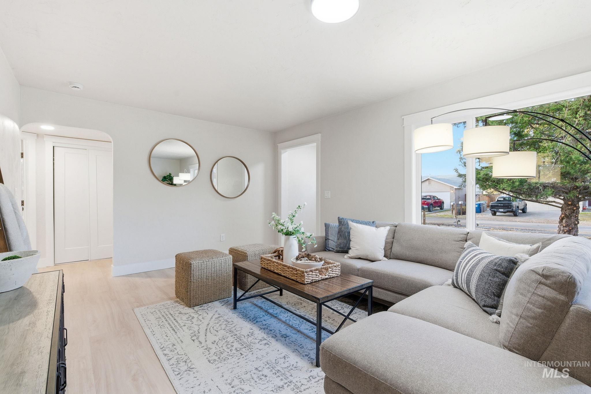 Living area with light wood-type flooring and arched walkways