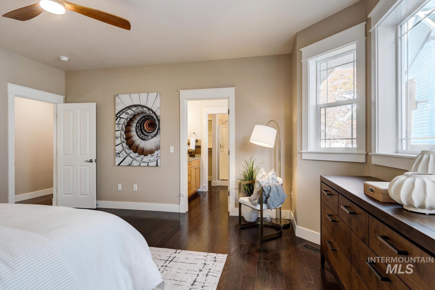 Bedroom featuring dark wood-style floors, connected bathroom, and ceiling fan