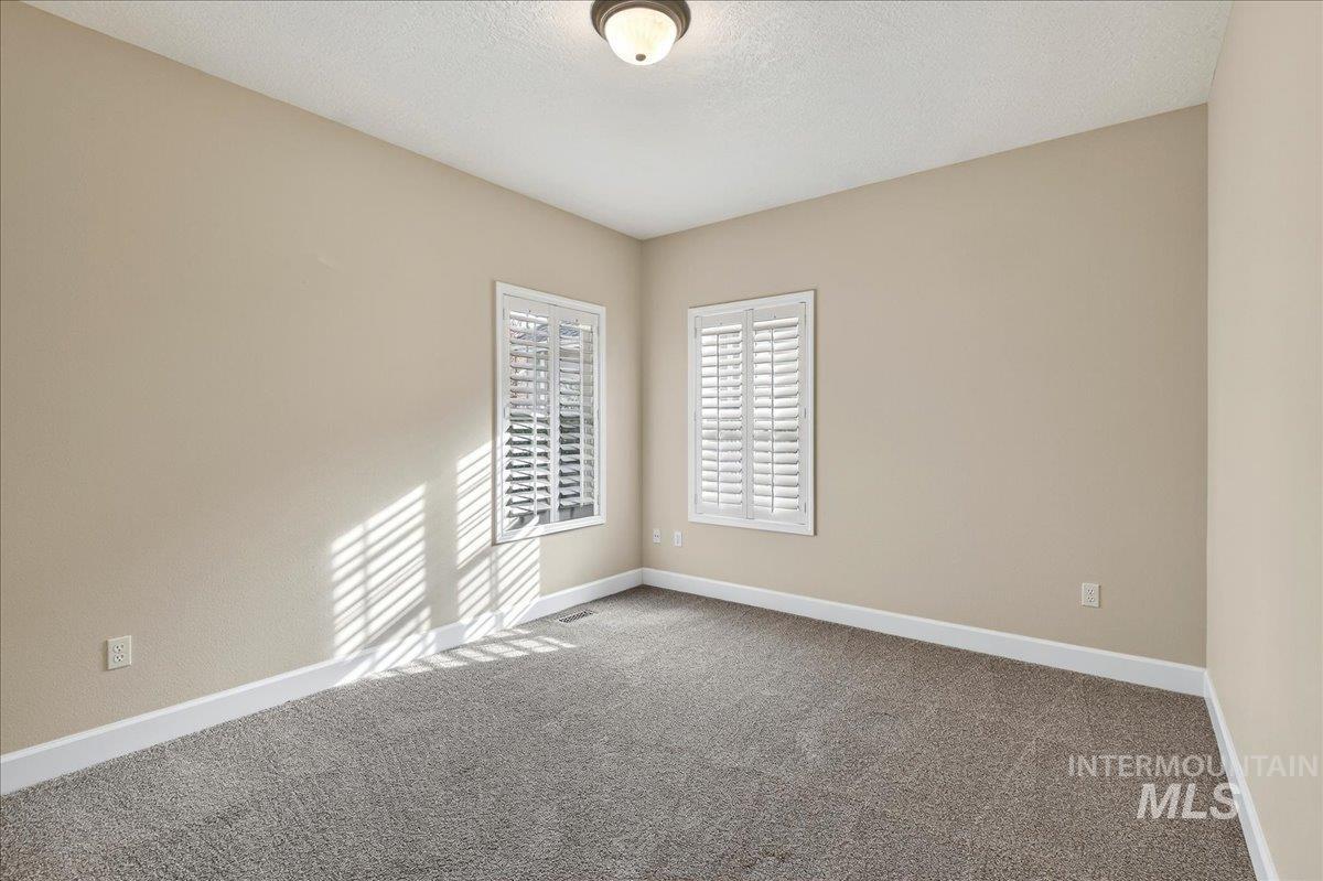Spare room featuring carpet and a textured ceiling