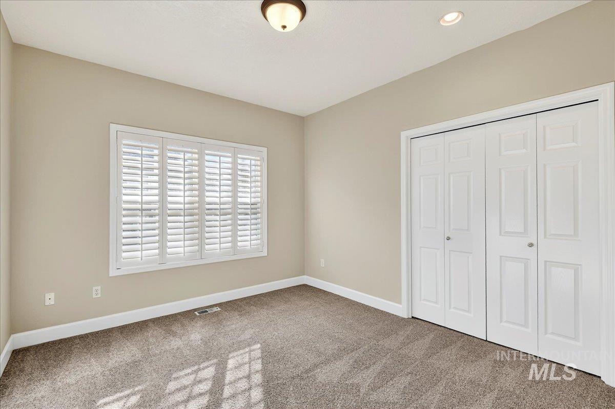 Unfurnished bedroom with carpet, a closet, and recessed lighting