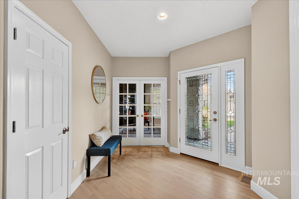 Entryway with french doors, light wood-style flooring, and recessed lighting