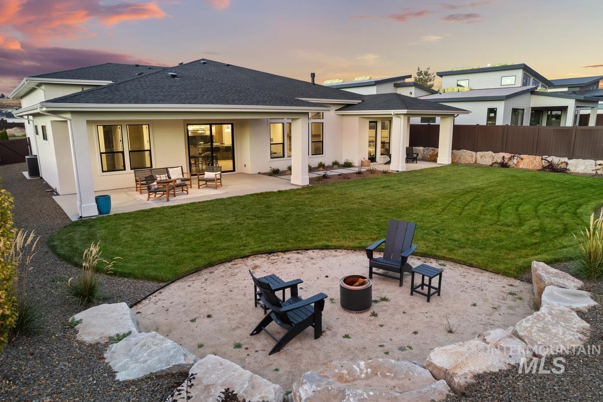 Rear view of property featuring a patio, a shingled roof, and stucco siding
