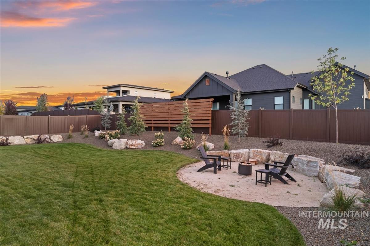 Fenced backyard featuring a patio area and a fire pit