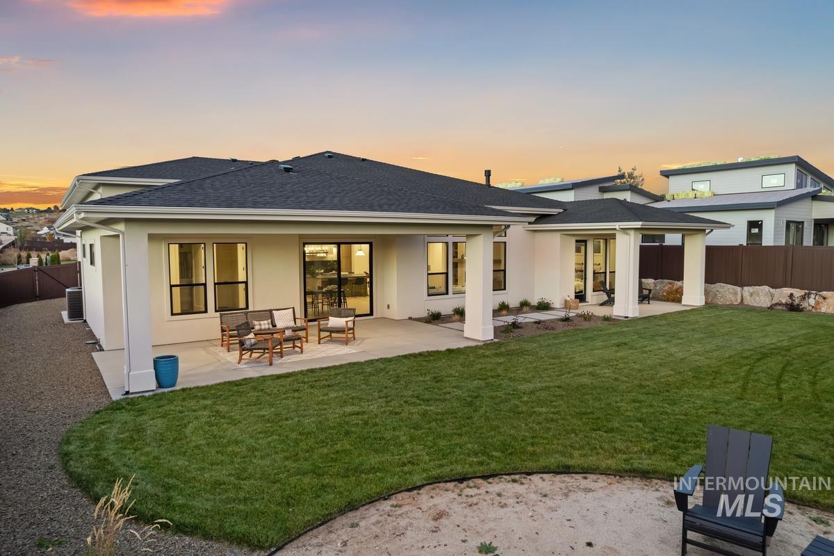 Back of property with a patio area, a fenced backyard, stucco siding, and roof with shingles