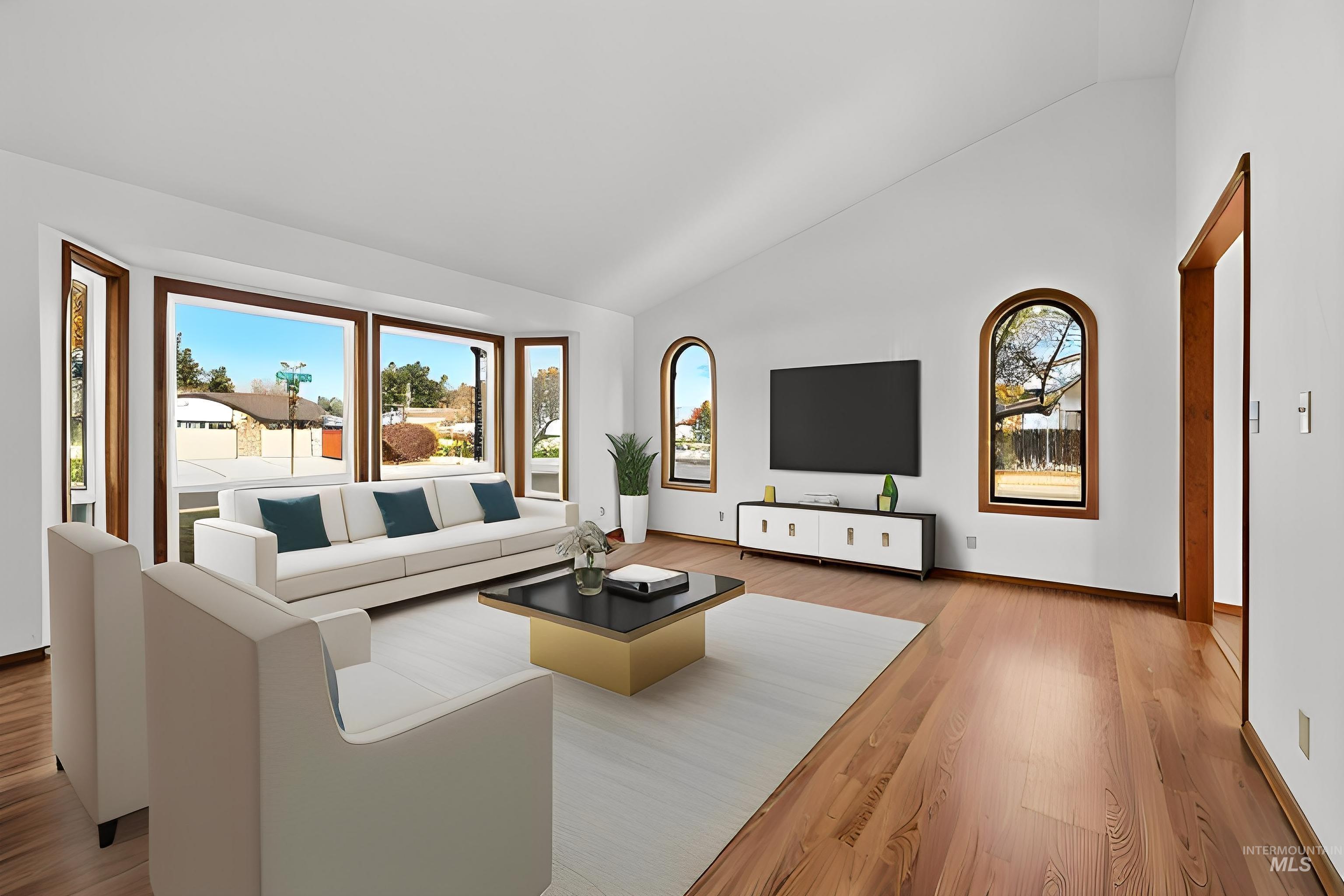 Living room with wood finished floors and high vaulted ceiling