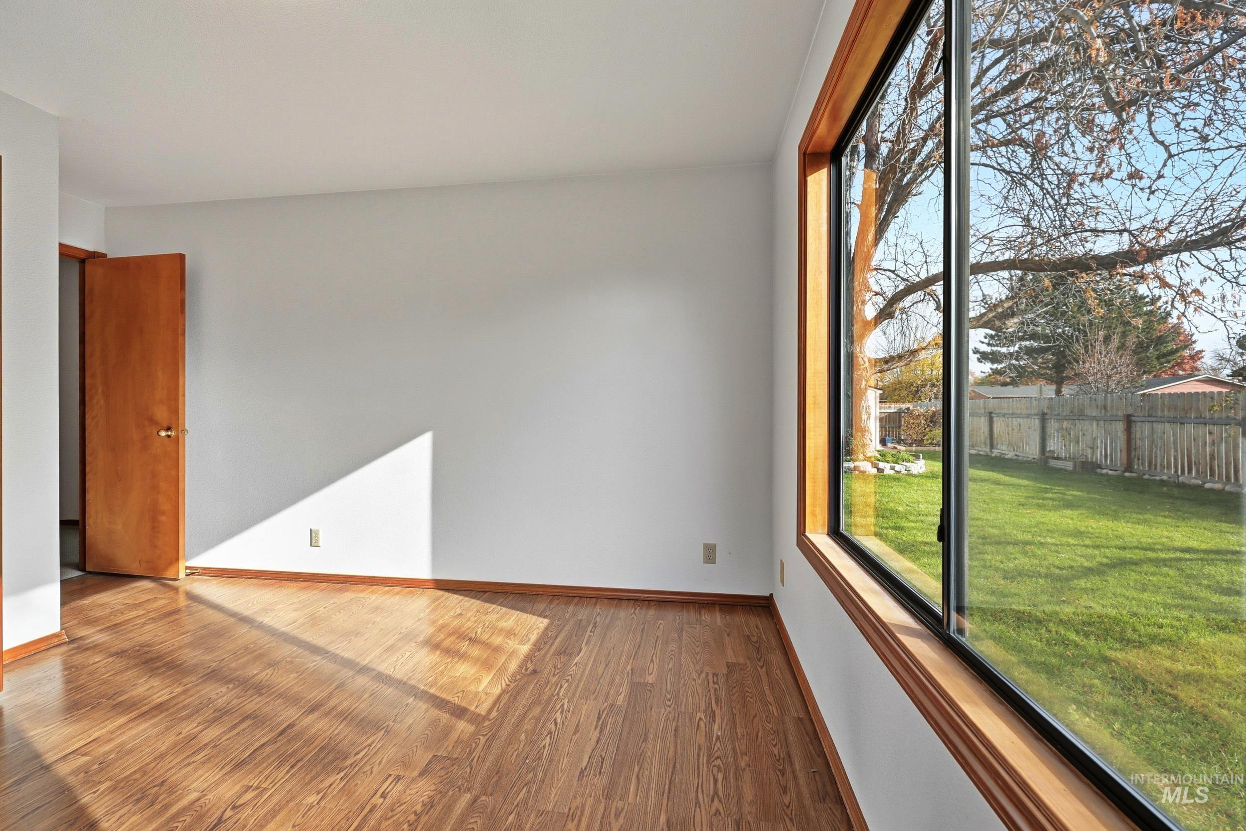 Unfurnished room featuring wood finished floors and baseboards