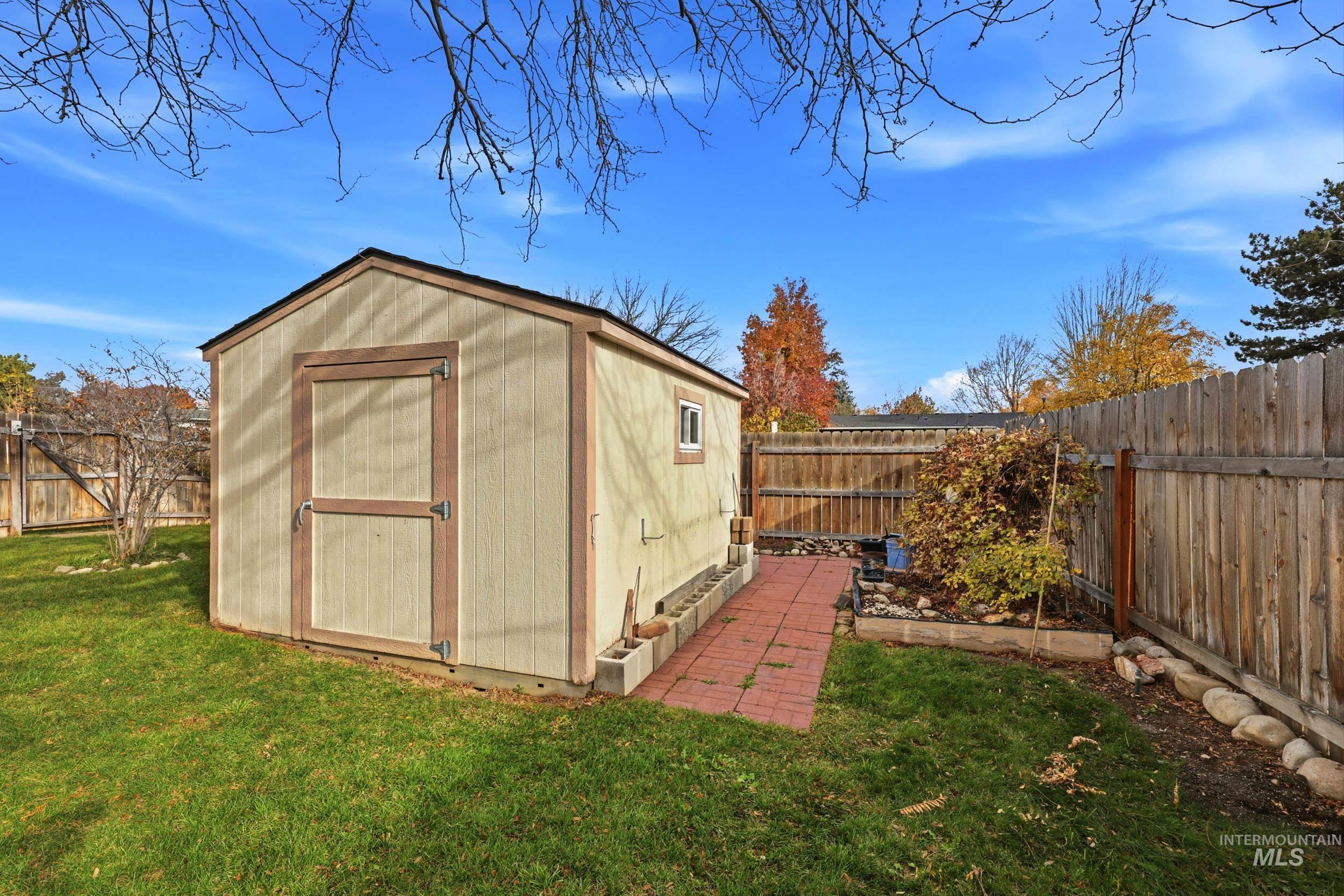 View of shed with a fenced backyard and a vegetable garden