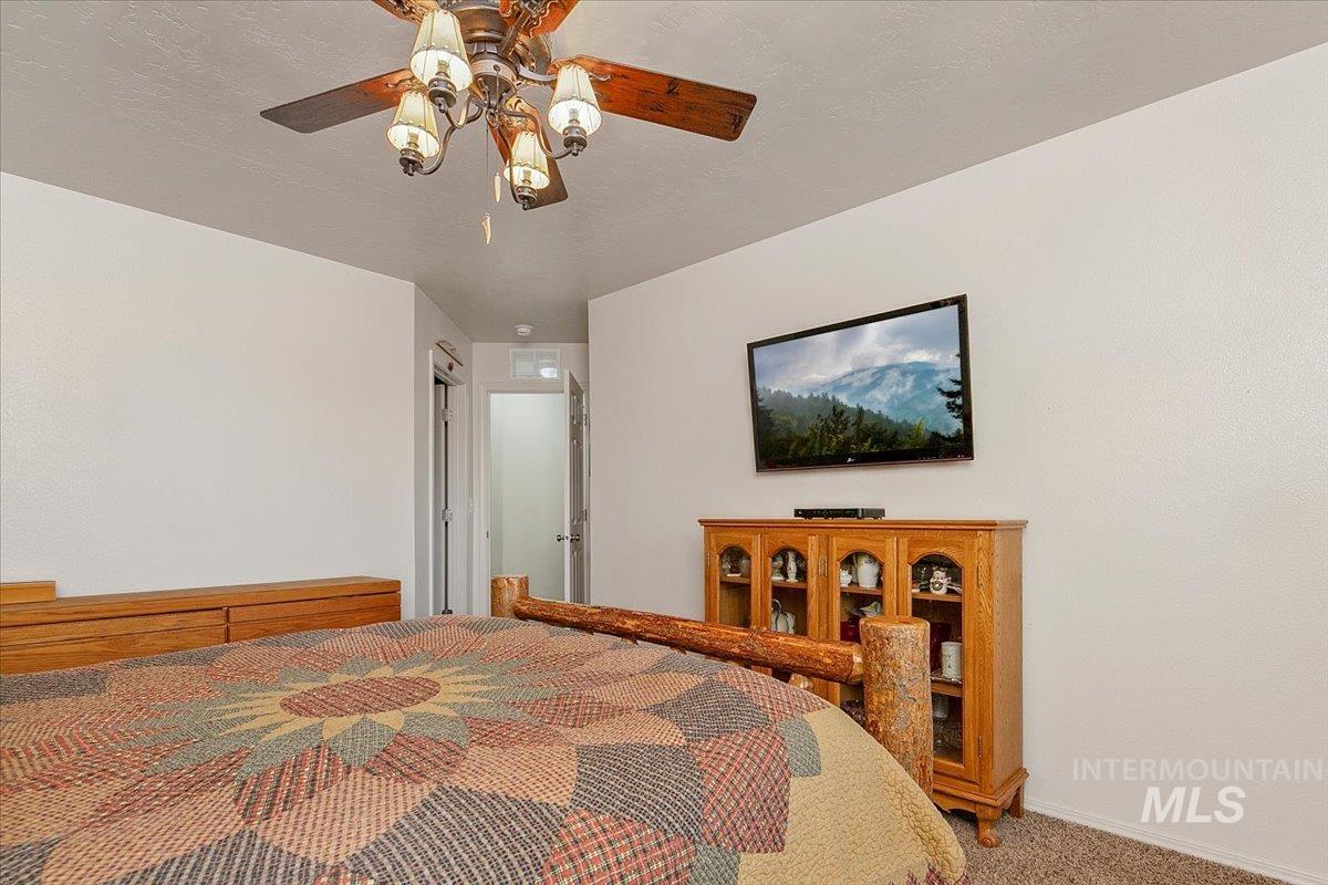 Carpeted bedroom featuring a ceiling fan and baseboards