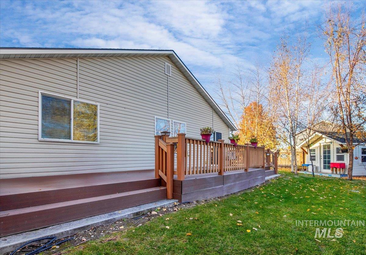 Back of house with a deck and a yard
