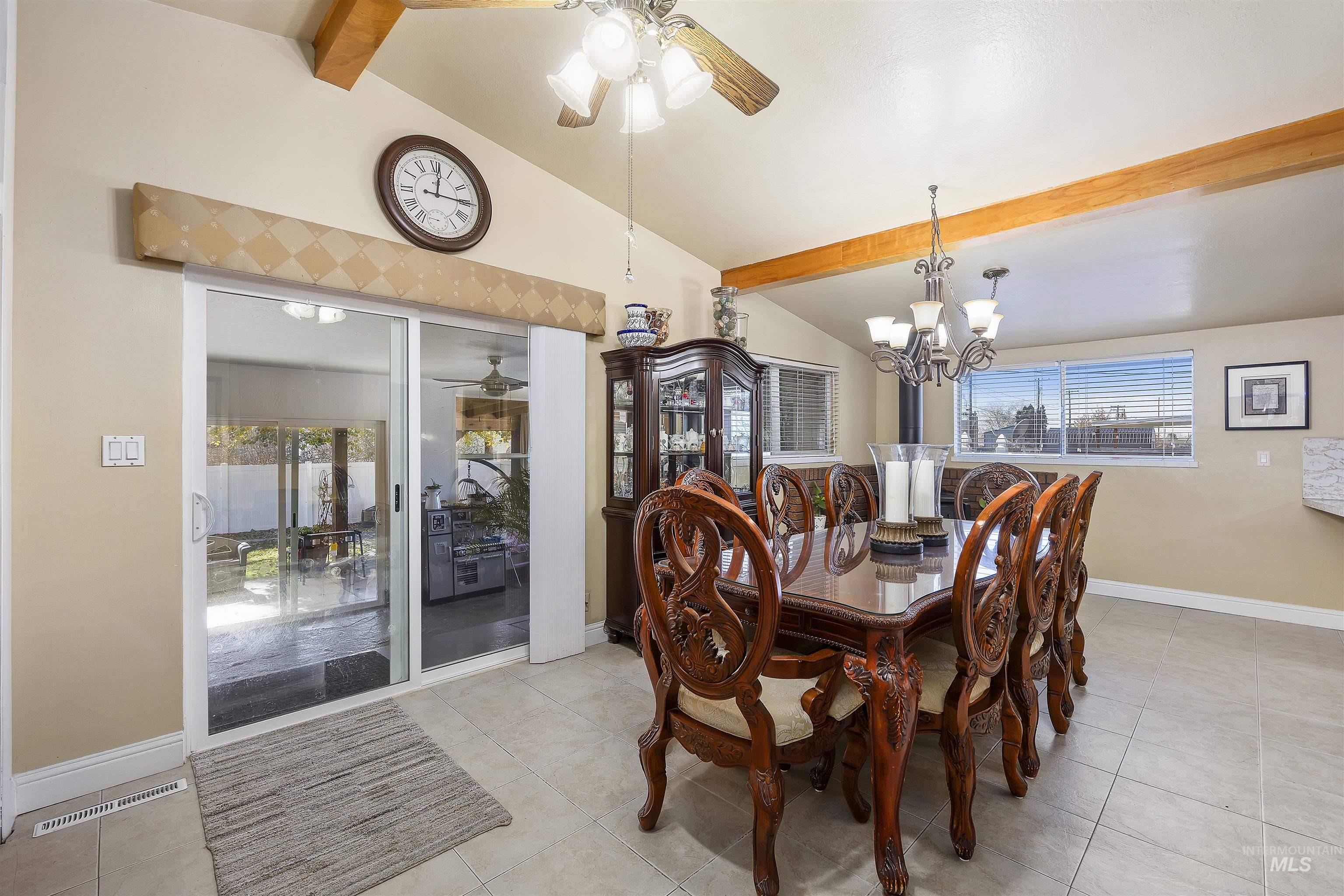 Tiled dining room featuring ceiling fan and a chandelier