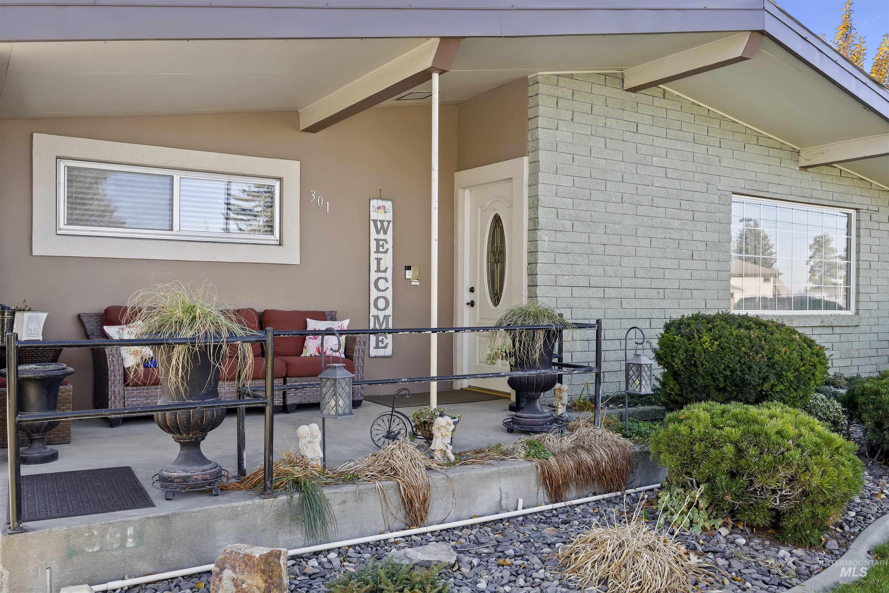 Doorway to property featuring brick siding and stucco siding