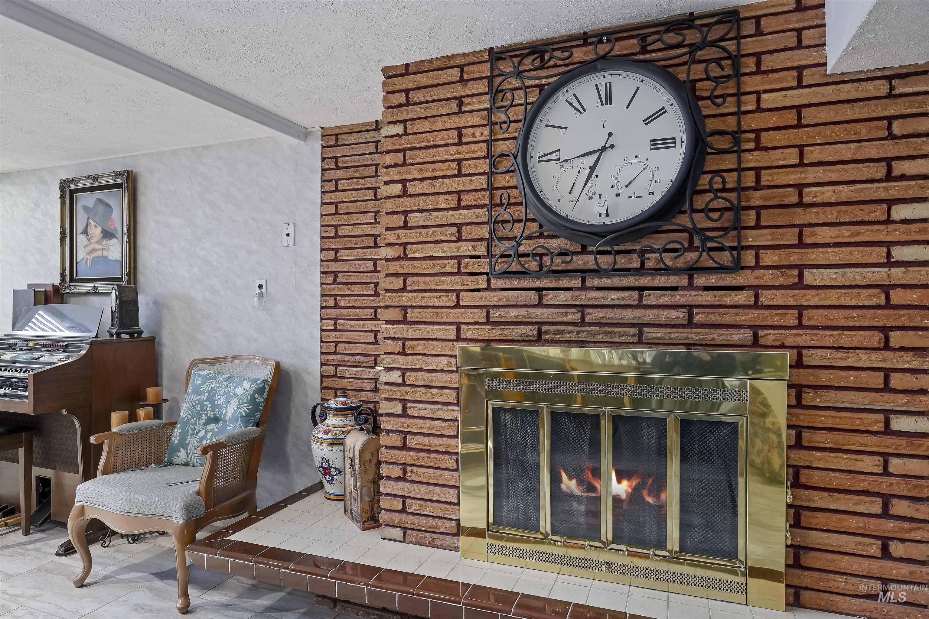 Tiled living area featuring beam ceiling, a textured ceiling, and a fireplace