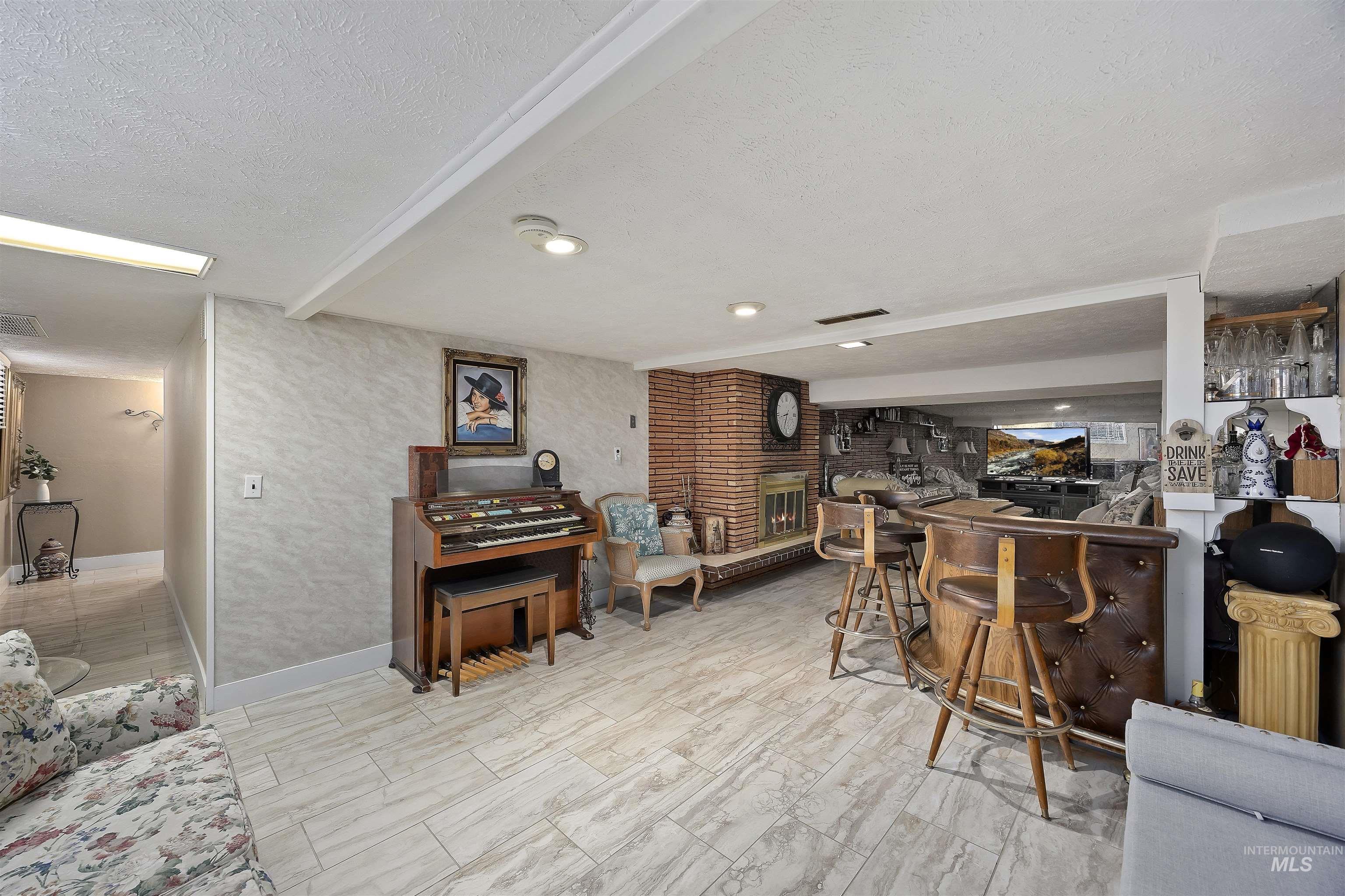 Indoor dry bar featuring a textured ceiling and beam ceiling