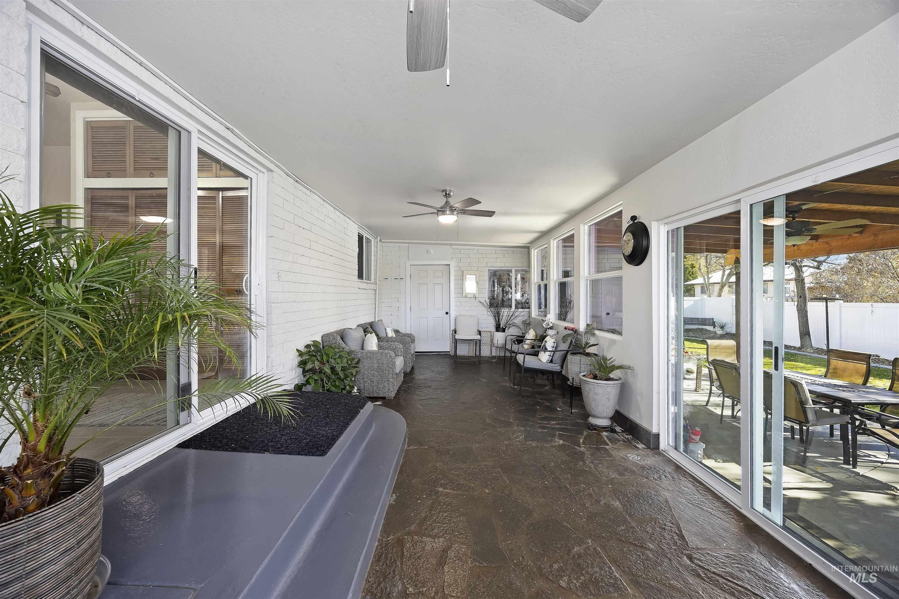 Sunroom / solarium with a ceiling fan, outdoor lounge area, and outdoor dining area