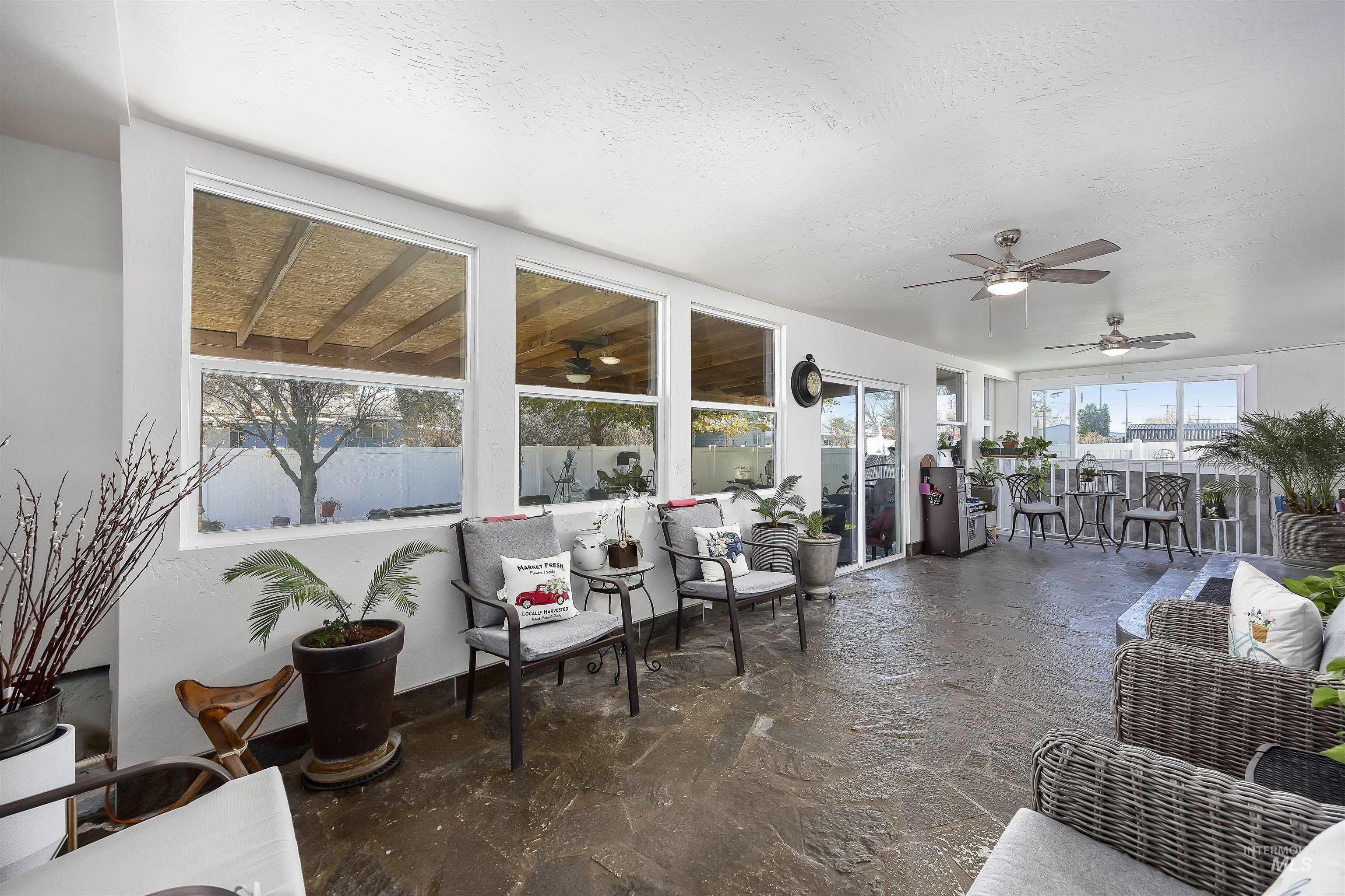 Sunroom with ceiling fan and a patio