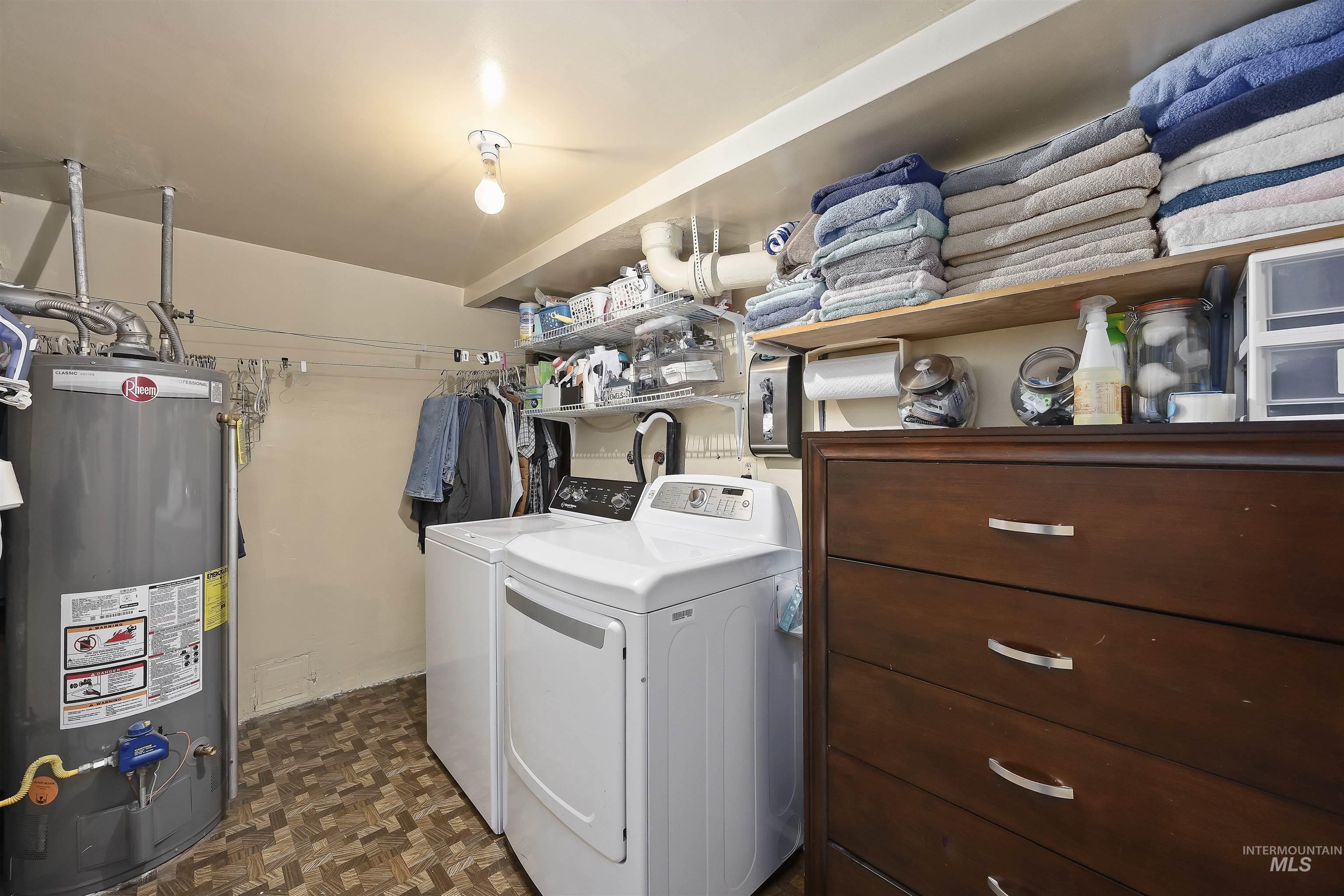 Laundry room featuring water heater and washer and clothes dryer